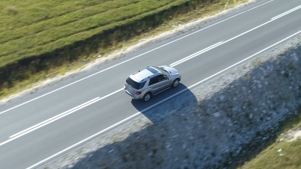 Aerial View of a Luxury Car Driving on Country Road alt