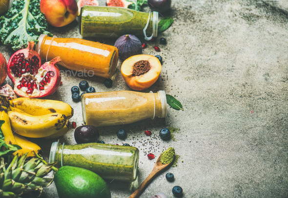 Colorful smoothies in bottles with fresh fruits, copy space - Stock Photo - Images