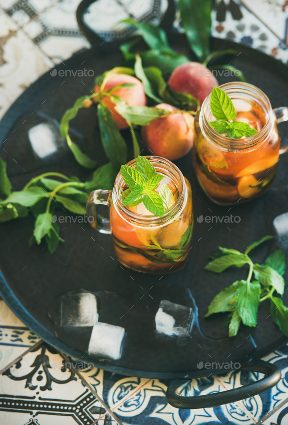 Summer refreshing cold peach ice tea in glass jars - Stock Photo - Images