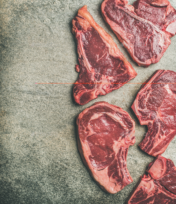 Porterhouse, t-bone and rib-eye steaks over grey background, copy space - Stock Photo - Images