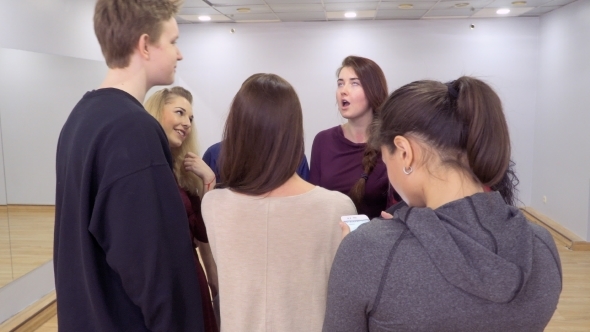 Girl Use Phone While Colleagues-actors Discusses Their Performance in Theatre alt