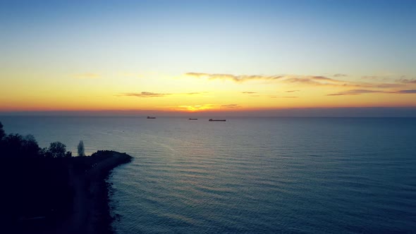 Cargo Ships Off The Coast In Sunrise Or Sunset At Sea