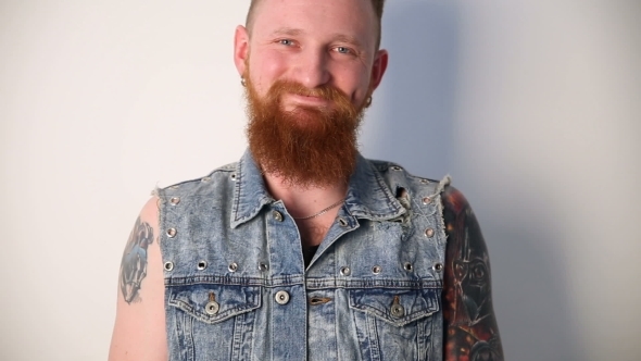 Modern Youth a Cheerful Portrait of a Kindly Smiling Biker with Tattoos and a Stylish Beard and