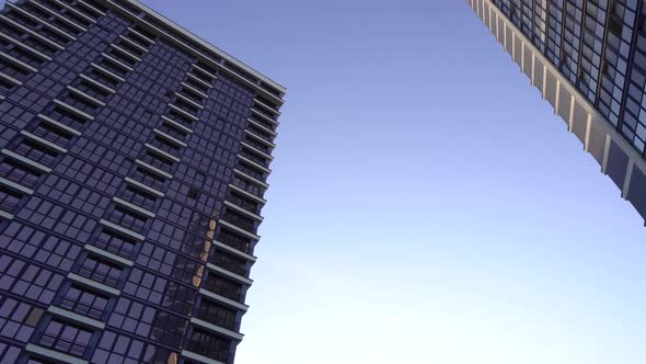 Panoramic low angle frame of Tall buildings with large glass Windows. 