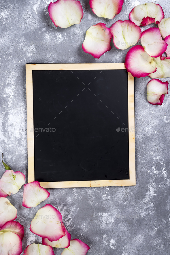 Beautiful rose flowers on gray stone table. Floral border. - Stock Photo - Images