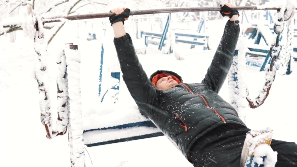 Young Muscular Man Has the Training and Doing Exercise Outdoors in Winter Time