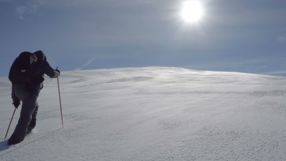 Hiker Climbs the Snow-covered Hill alt