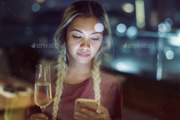 Serious young woman using a smartphone at a rooftop bar in the e Stock Photo by Rawpixel