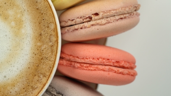 Pastel Macarons Around a Coffee Cup alt