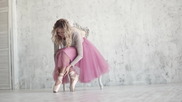 Ballerina Tying the Pointes. Ballet Dancer Wearing Ballet Shoes in the Studio alt