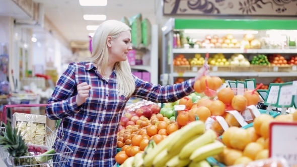 Woman Chooses Fruit in a Supermarket
