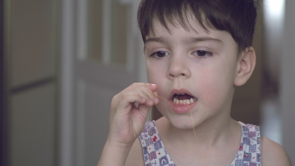 The Boy Tries To Pull Out His Milk Tooth with a Thread.