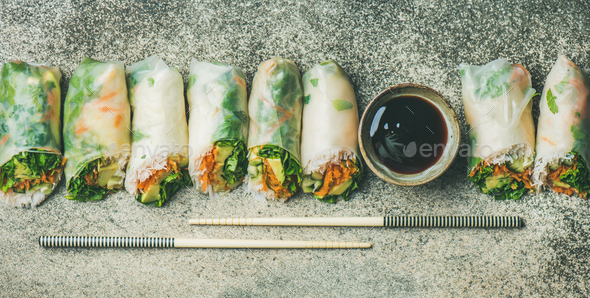 Vegan spring rice paper rolls over concrete background, wide composition - Stock Photo - Images