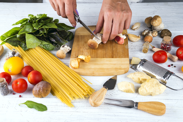 Close up hands only view of woman in apron cutting mushrooms, - Stock Photo - Images