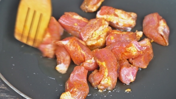 Shot of a Meat Cooking in the Frying Pan Man Is Stirring It with a turner alt