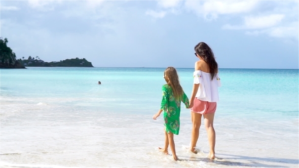 Beautiful Mother and Daughter on Caribbean Beach Walking on Tropical Seashore. alt