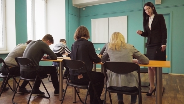 Woman Teacher Check Students Progress During a Lesson in Classroom