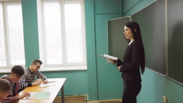 Woman Teacher Standing in Front of Students During a Lesson in Classroom