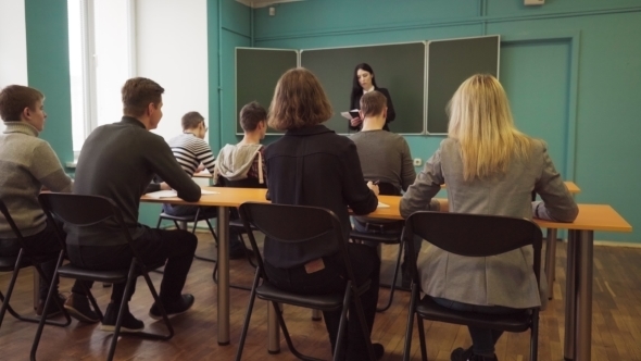 Woman Lecturer Speaks To Students in Classroom
