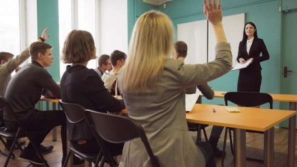 Students Raise Hands After the Teacher's Question During Lecture