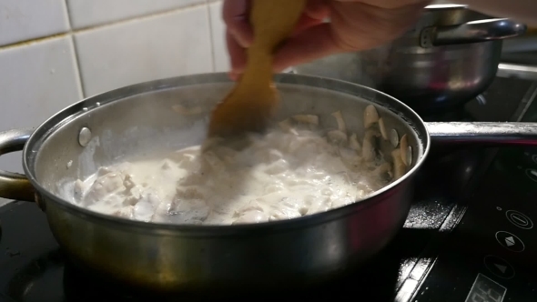 A Tasty Dish From Sliced Meat, Mushrooms and White Sauce Is Mixed with a Spatula