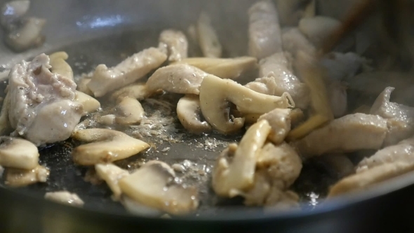 A Flavourous Dish From Sliced Meat and White Mushrooms Is Mixed with a Spatula