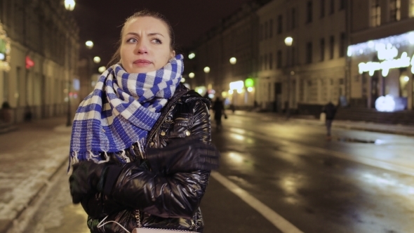 Young Girl Feels Herself Cold During Waiting Friends at the Urban Street alt