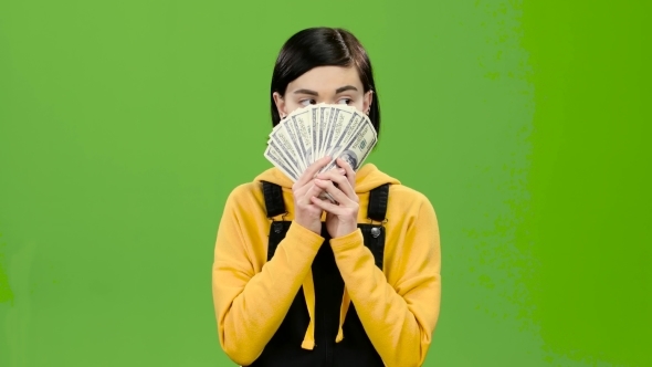 Girl Holds Paper Bills in Her Hands and Rejoices in Victory. Green Screen alt