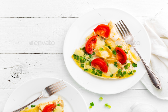 Omelet. Eggs fried. Scrambled eggs with green onion and fresh tomato. Omlette on white plate - Stock Photo - Images