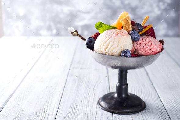 Bowl with ice cream with three different scoops of white, yellow, red colors and waffle cone - Stock Photo - Images