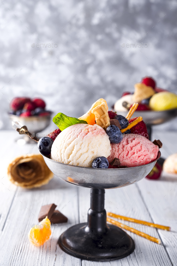 Bowl with ice cream with three different scoops of white, yellow, red colors and waffle cone - Stock Photo - Images