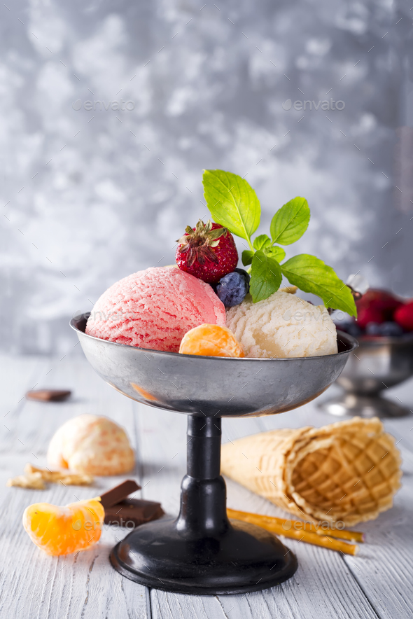Bowl with ice cream with three different scoops of white, yellow, red colors and waffle cone - Stock Photo - Images