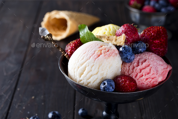 Bowl with ice cream with three different scoops of white, yellow, red colors and waffle cone - Stock Photo - Images