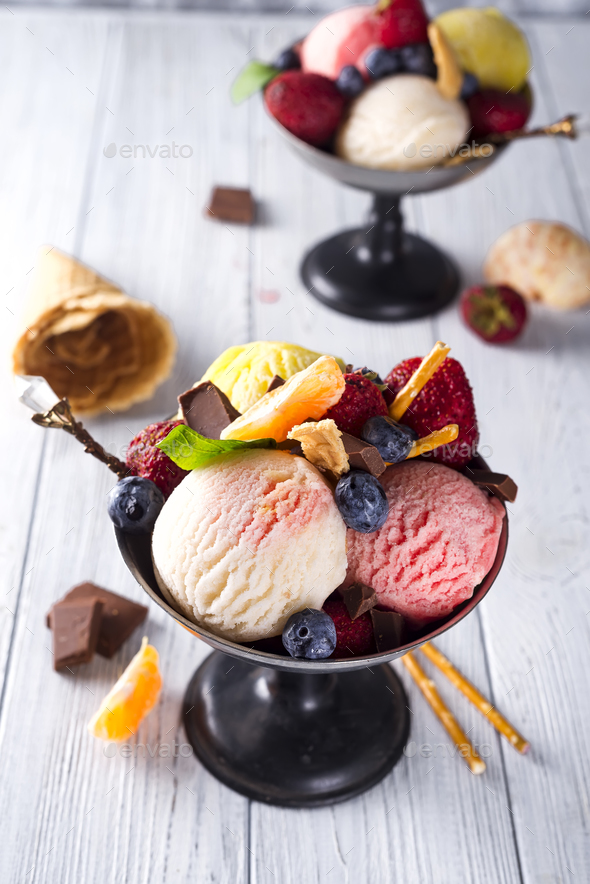 Bowl with ice cream with three different scoops of white, yellow, red colors and waffle cone - Stock Photo - Images