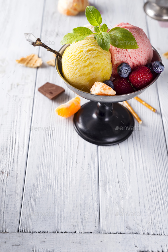 Bowl with ice cream with three different scoops of yellow, red colors and waffle cone, chocolate, - Stock Photo - Images