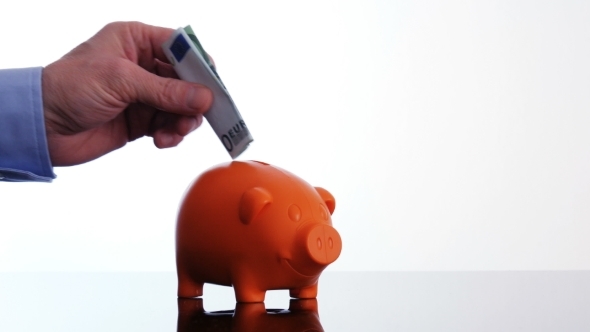 Male Hand Putting a Euro Bill in a Piggy Bank