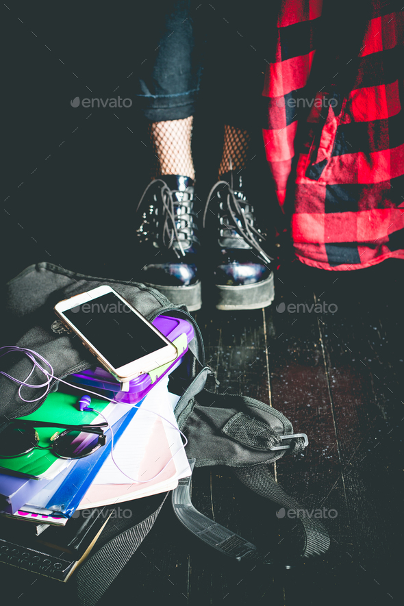 Young alternative girl on the black floor with a school bag - Stock Photo - Images
