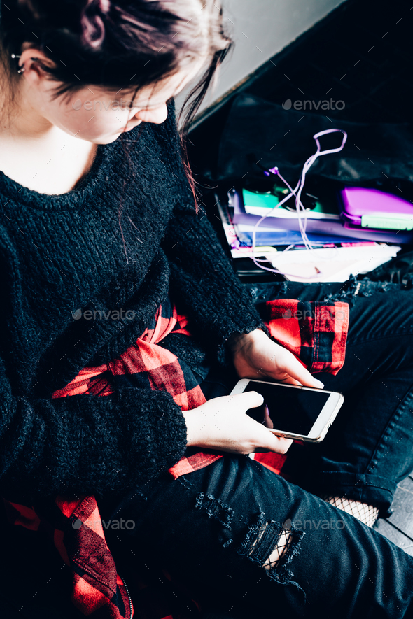 Young alternative girl sitting on the black floor with a school - Stock Photo - Images