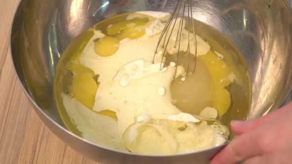 Confectioner Fast Mixer Mixes the Egg Yolks and Sugar in a Metal Bowl