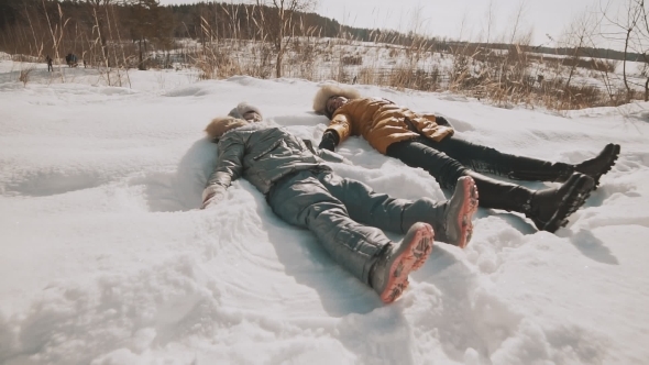 A Mother and Baby Are Making Angels on the Snow Family Have Fun with Copyspace