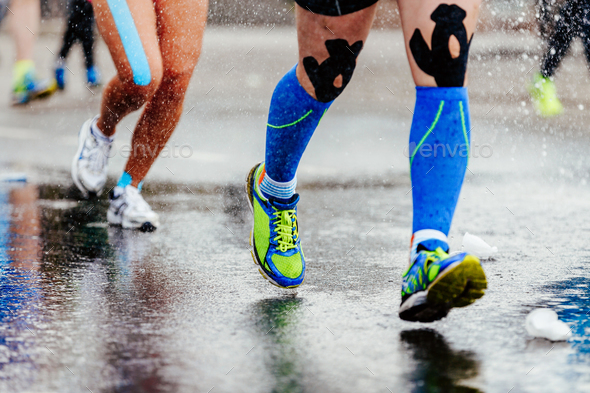 legs runner in compression socks and kinesiology tape on knees running on water Stock Photo by sportpoint74