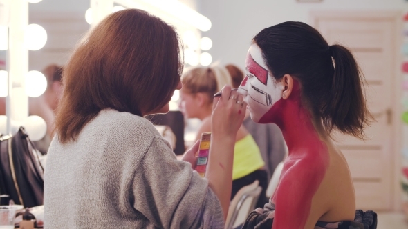 Makeup Artist Painting with Red Color on the Face