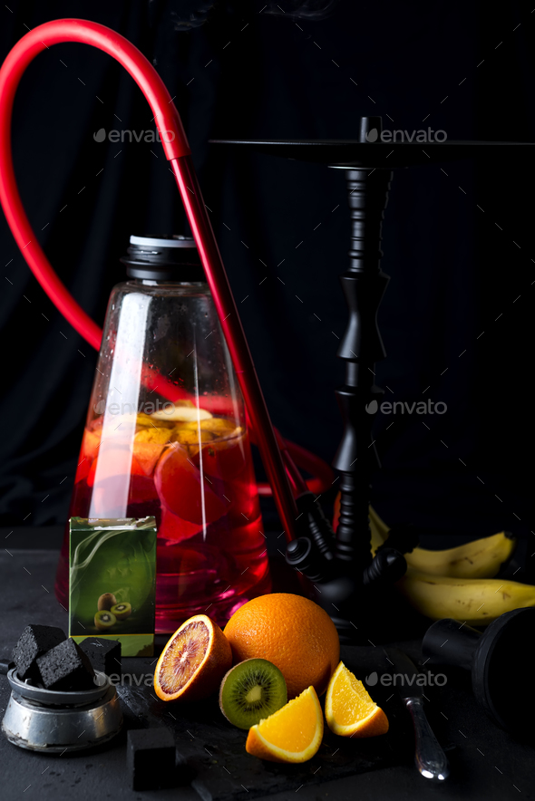 Red hookah with orange slice on a black background - Stock Photo - Images