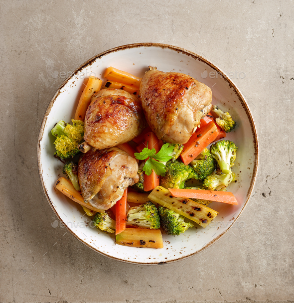 Plate of grilled chicken legs and vegetables Stock Photo by magone