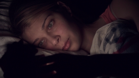 Young Woman Using Smartphone in Bed