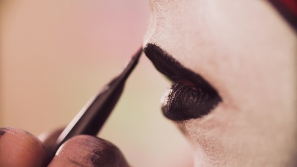 The Makeup Artist Applying Black Color on the Lips