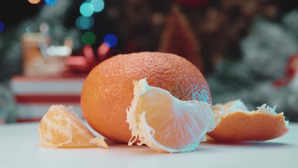 A peeled mandarin is spinning on a white table.