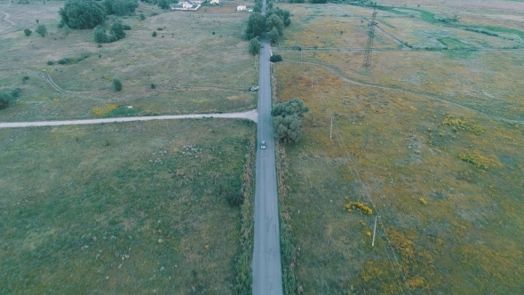 Aerial View of Road Between Green Fields