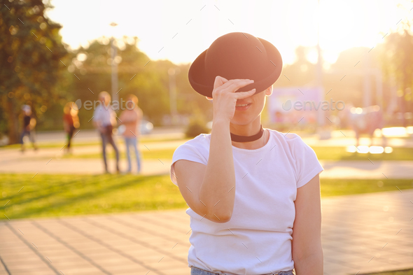 Beautiful woman hiding face behind hat showing eyes - Stock Photo - Images