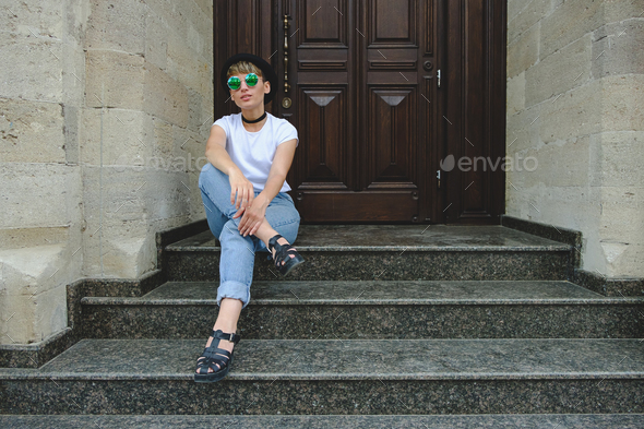 Beautiful young hipster woman posing sitting on stairs - Stock Photo - Images